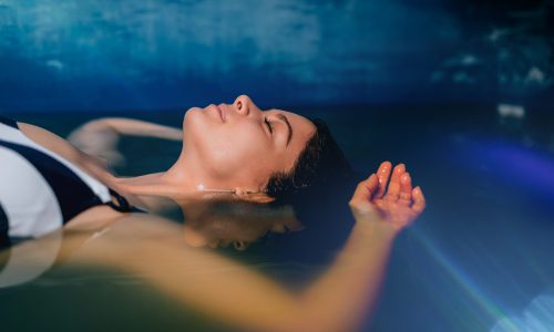 Beautiful,Woman,Floating,In,Tank,Filled,With,Dense,Salt,Water
